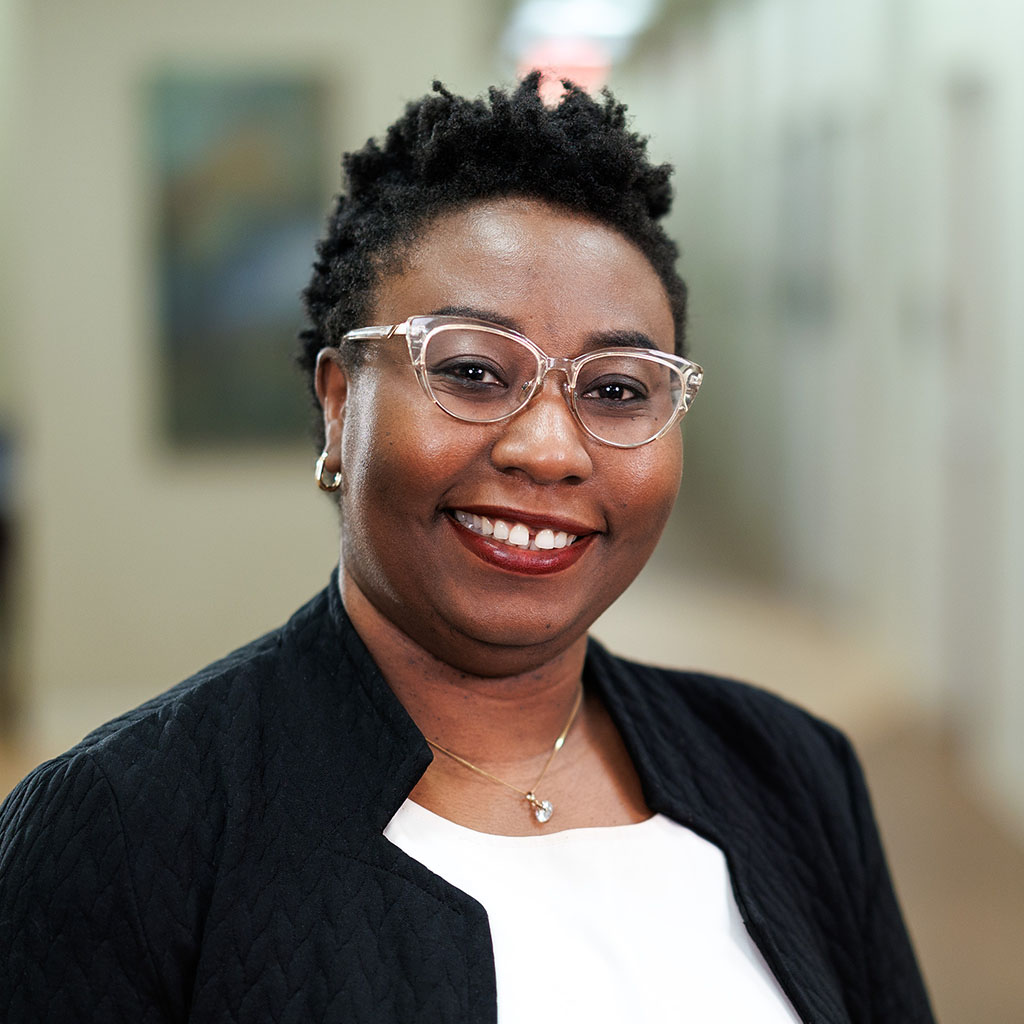 Chiamaka Anosike smiling while standing in a hallway at Mercer Medicine