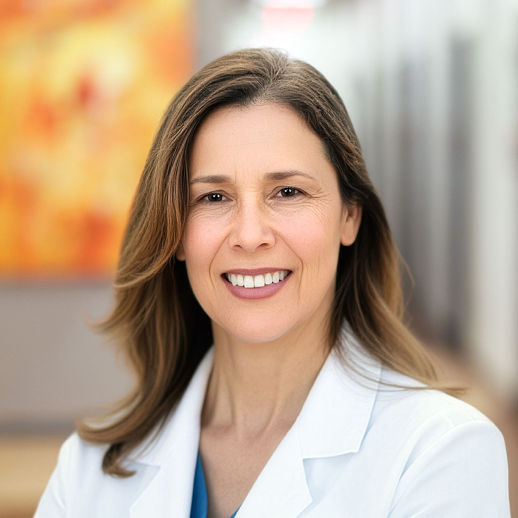 Nurse practitioner Michele Scarborough is standing in the clinic hallway and is smiling.