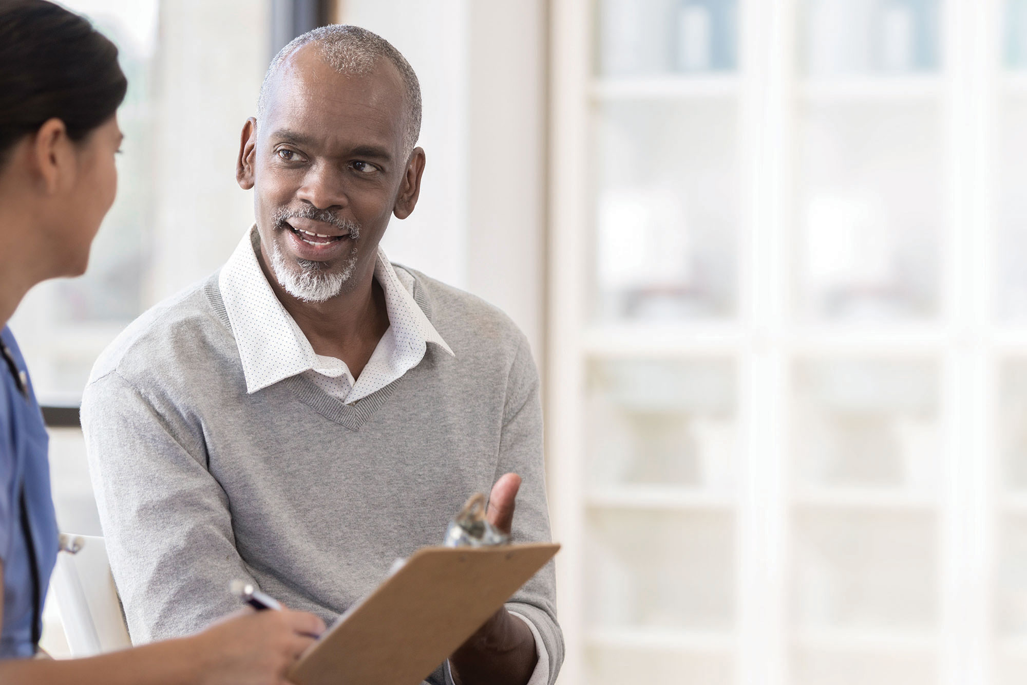 Older man talking with nurse