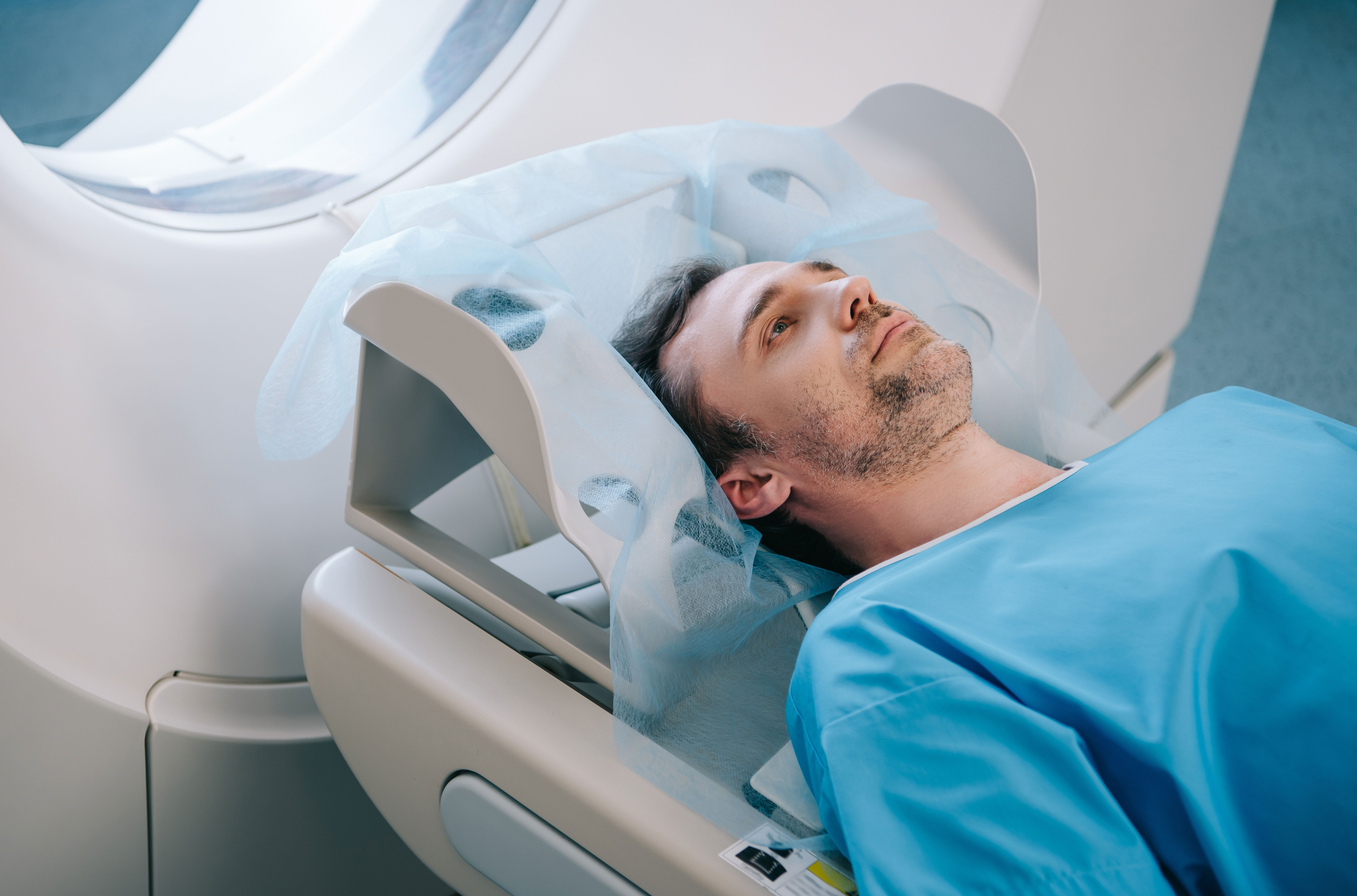 Male patient lying in a CT scanner during a heart CT calcium scan procedure.